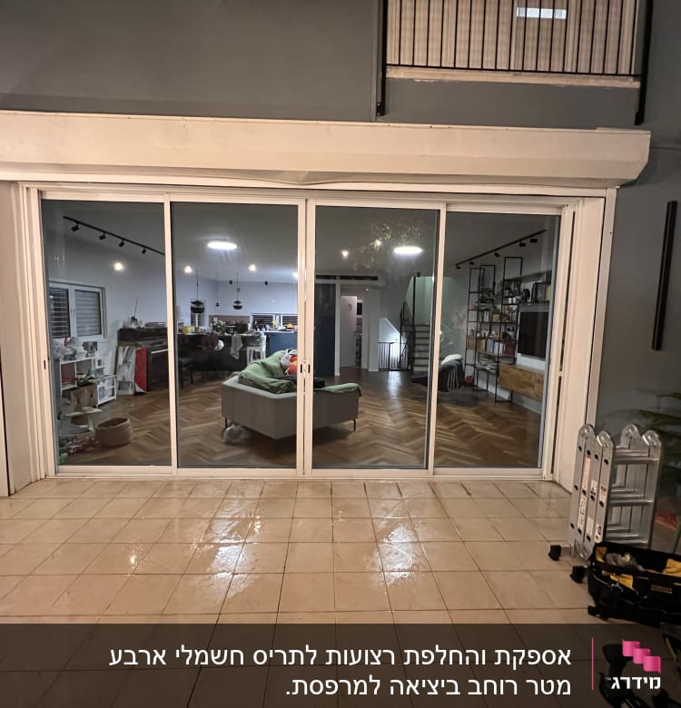 תריסים לבנים סגורים על חלון זכוכית גדול